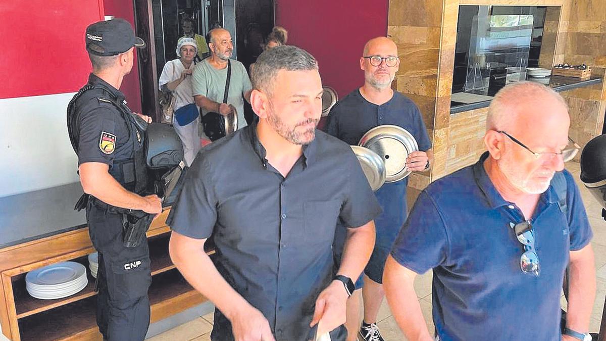 Empleados del hotel, durante el desalojo de las cocinas en verano ante la presencia policial.