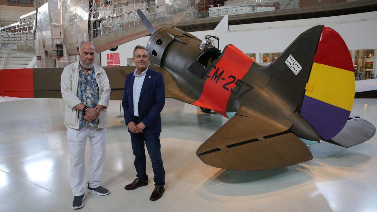 El artista Francesc Torres y el director del Centro de Aviación Histórica de La Sénia, José Ramón Bellaubí (derecha), ante la réplica del caza soviético 'Mosca', en la Sala Oval del MNAC.