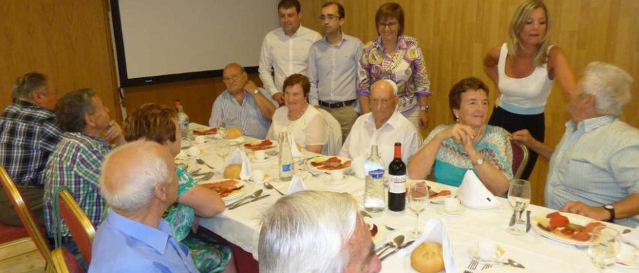 De pie, el concejal Sergio Boto, el alcalde, José Víctor Rodríguez, la consejera Pilar Varela y la gerente del ERA Graciela Blanco, con asistentes al encuentro en Cangas.