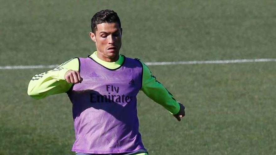 Cristiano Ronaldo toca la pelota ayer en el entrenamiento del Madrid.