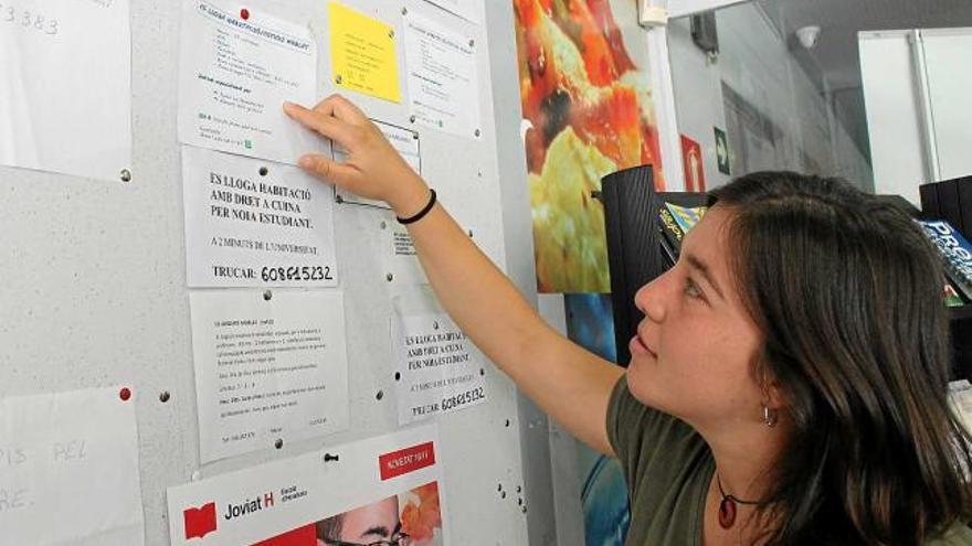 Una estudiant consulta la cartellera de la cafeteria de la FUB, on la gent penja anuncis de pisos, entre d&#039;altres