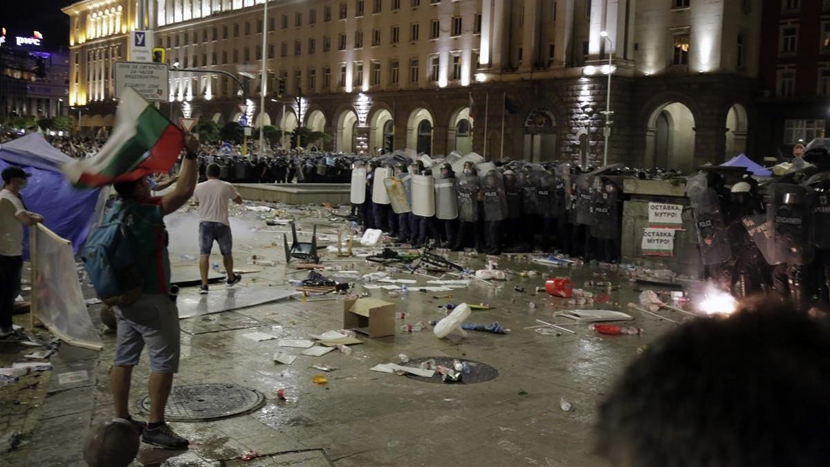 Manifestantes lanzan botellas contra la policía durante una protesta en Sofia.