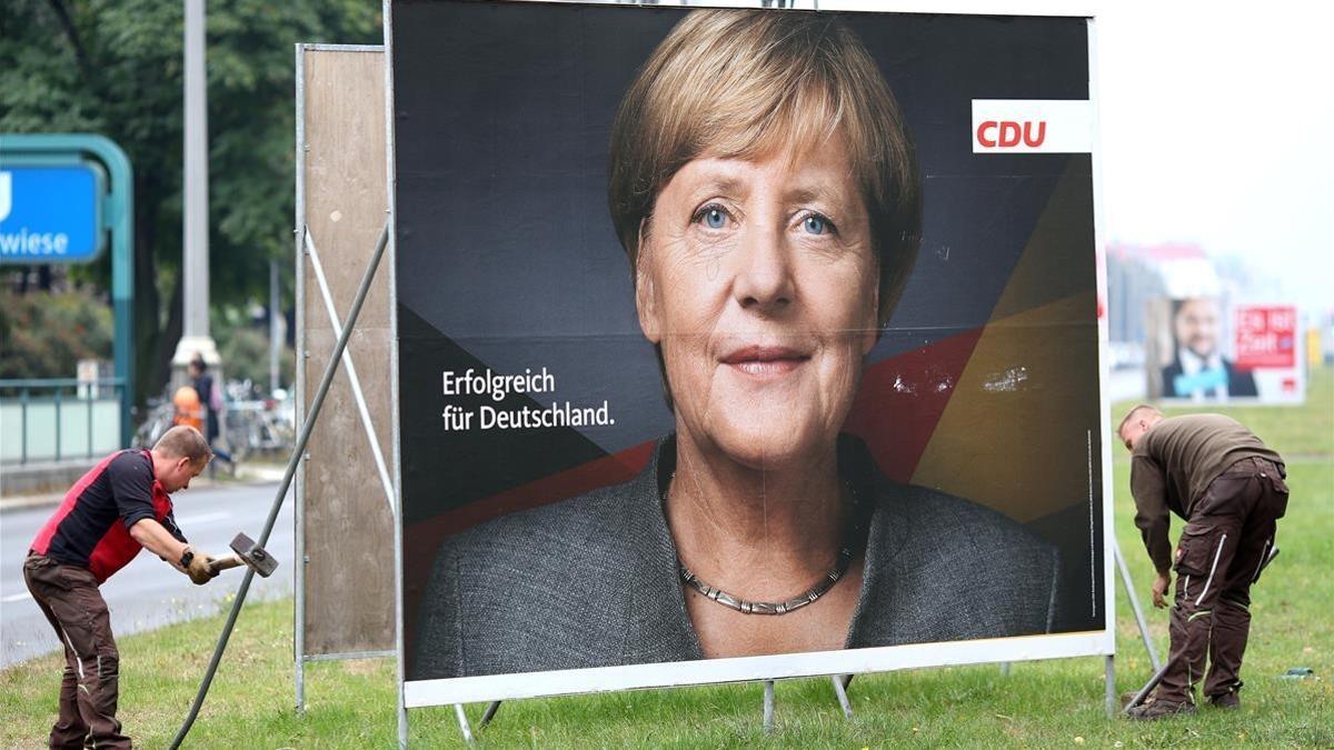 Retirada de un cartel electoral de Angela Merkel en Berlín