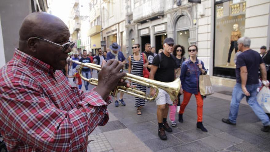 El trompetista Nilo Caparrosa ameniza las compras de estas Navidades en la calle del Castillo.