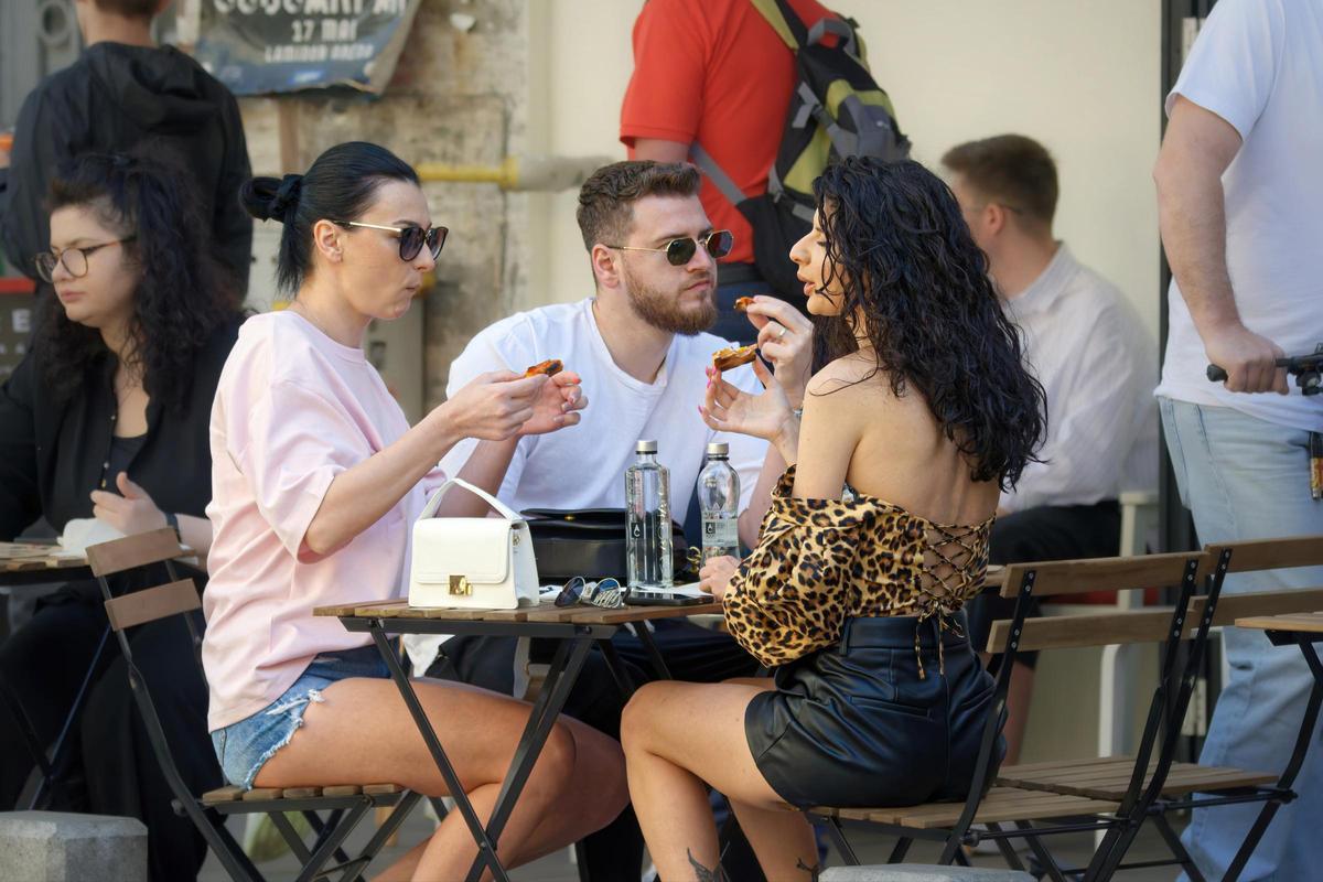Varios turistas picoteando algo en una terraza