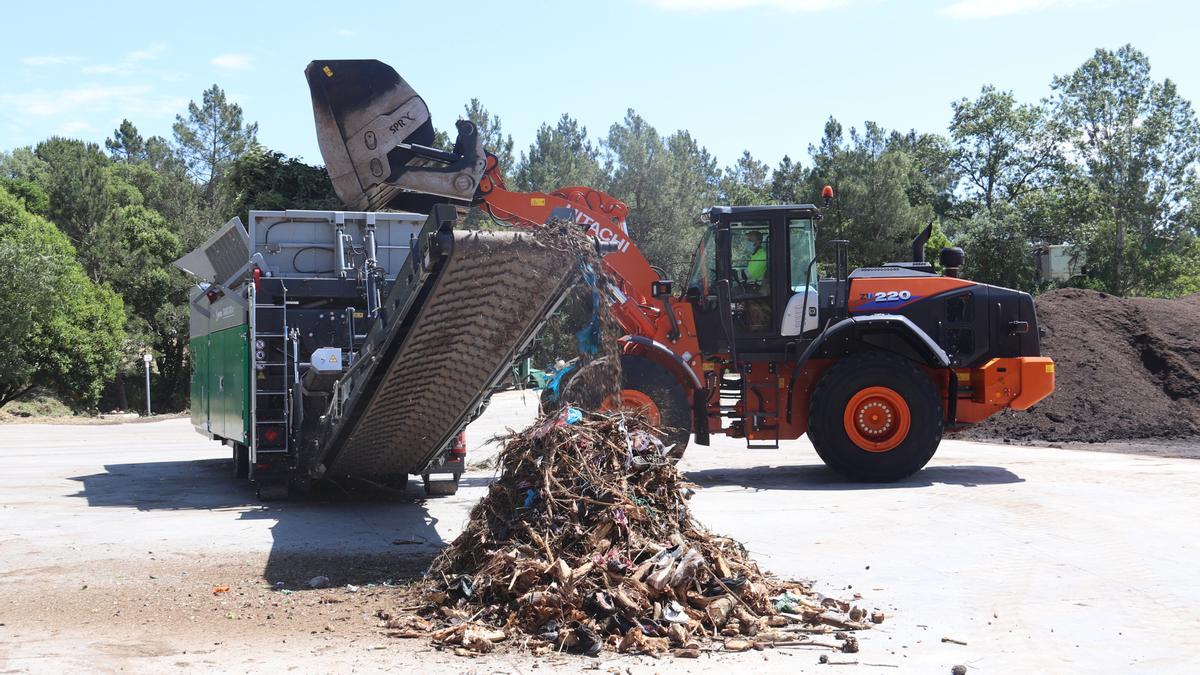 Una trituradora processa restes vegetals a la planta de gestió de residus de Santa Coloma de Farners