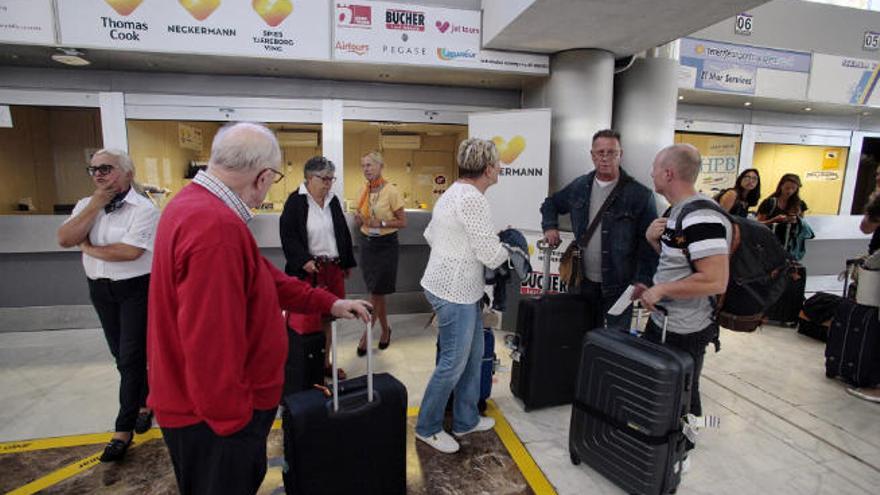 Afectados por la quiebra de Thomas Cook, frente a la ventanilla del turoperador en el aeropuerto Tenerife Sur.