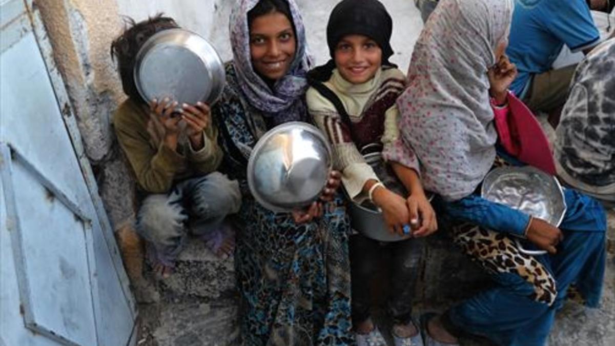 Unas niñas, a las puertas de un campo de refugiados en Ain Issa (Siria).