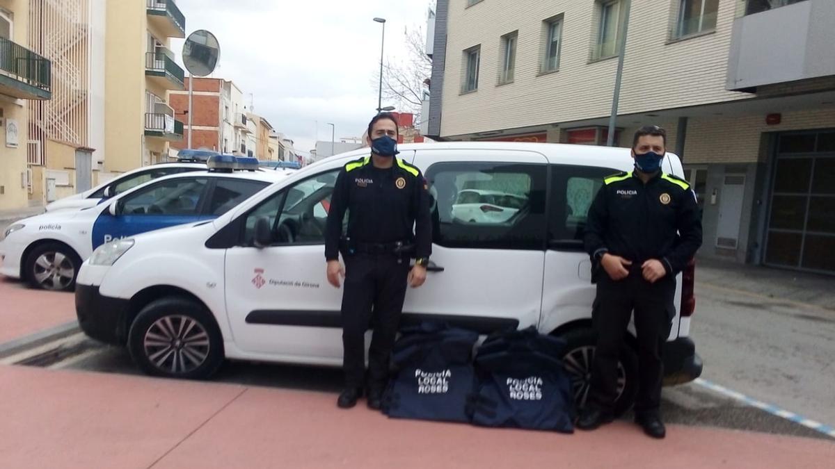 Dos agents de la Policia Local de Roses entreguen a una furgoneta de la Diputació de Girona diverses armilles de protecció antibala