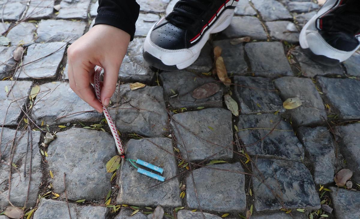 Un niño enciende unos petardos con una mecha en una imagen de archivo.