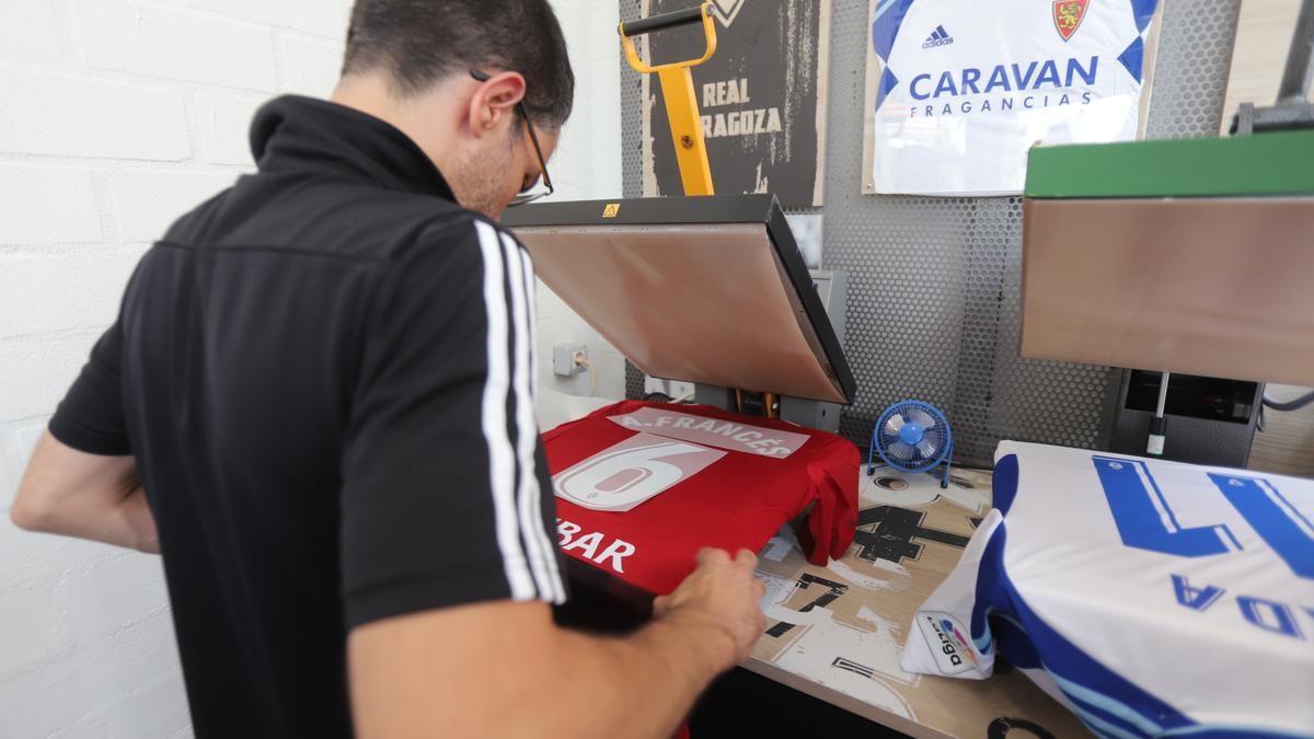 Un empleado de la tienda del Real Zaragoza preparando una camiseta con el nombre de Francés