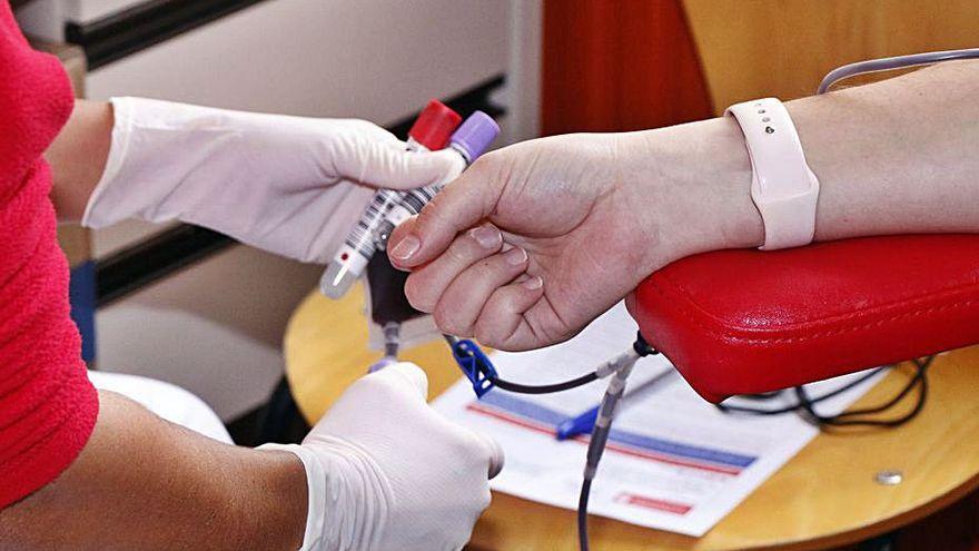 Una mujer dona sangre.