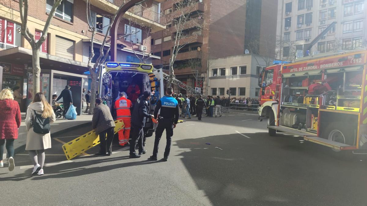 La mujer herida leve en un brazo se recupera del susto con su bebé en la parada del autobús.