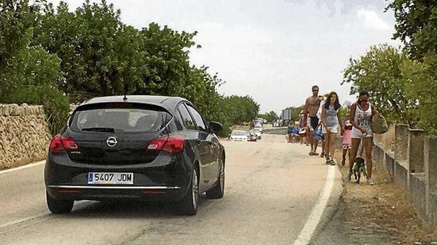 Turistas cruzando de forma temeraria la carretera para ir a Cala Varques.