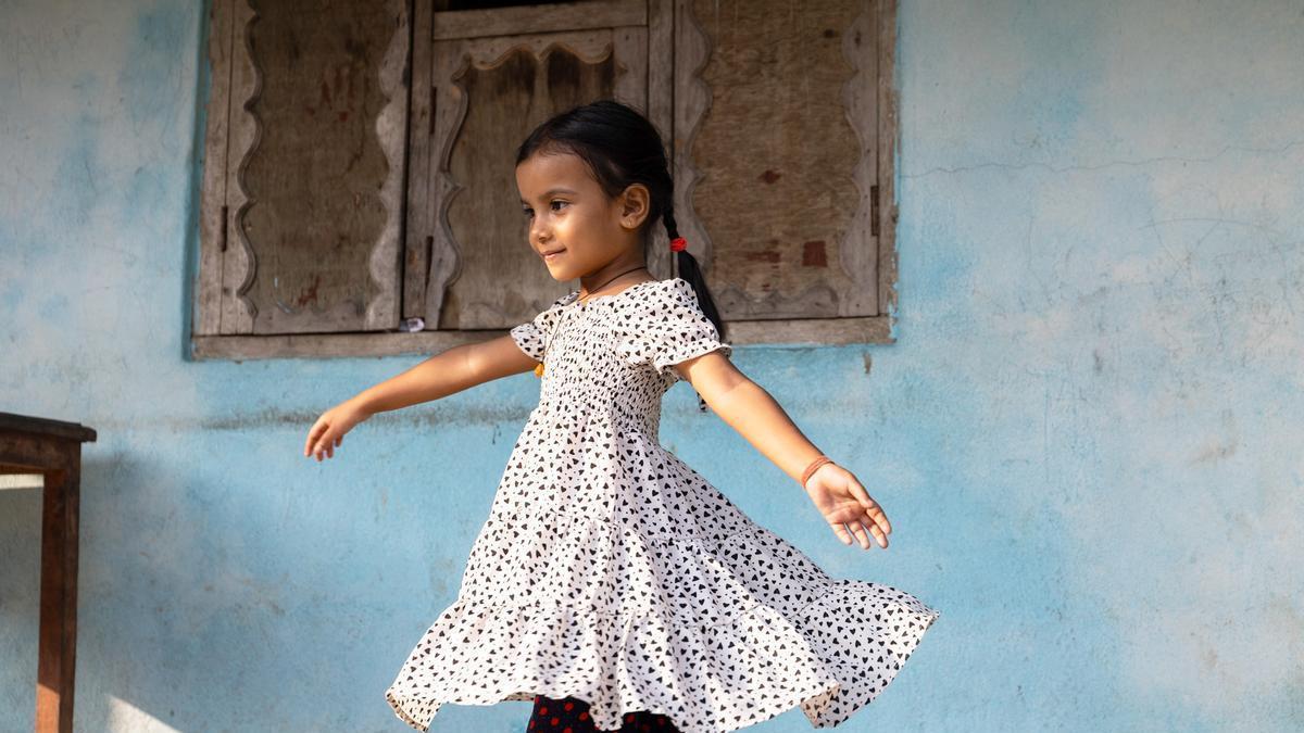 Niña bailando en una casa.