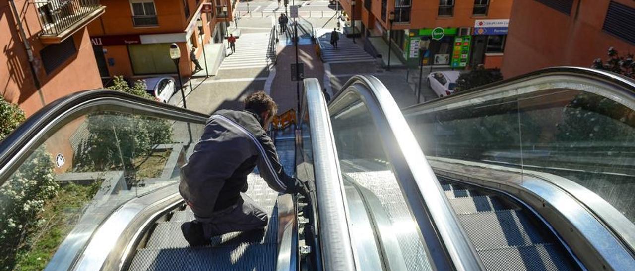 Un trabajador repara las escaleras mecánicas de Plasencia.