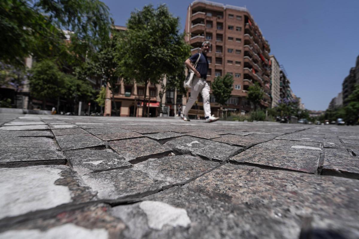 Un peatón pasa por un paso de cebra con el adoquinado maltrecho en la calle Pi i Margall, en Barcelona. Un peatón pasa por un paso de cebra con el adoquinado maltrecho en la calle Pi i Margall, en Barcelona.