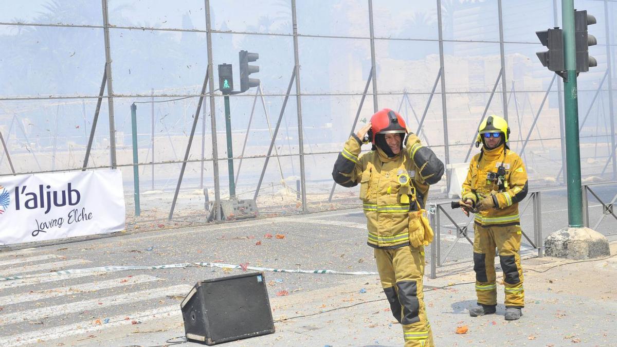 Los bomberos, en una mascletá en Traspalacio, con el Hort del Xocolater, al fondo. | ANTONIO AMORÓS