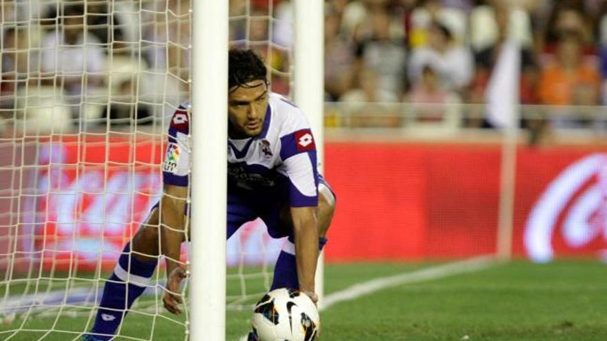 Abel Aguilar recoge el balón de la portería tras el primero de sus goles ayer en Mestalla. / LOF