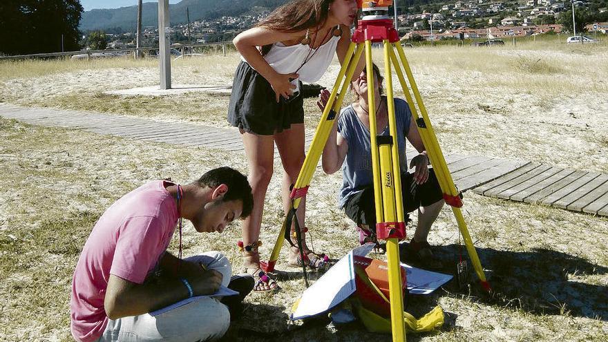 Jóvenes del campus haciendo estudios en una playa de la ría de Vigo. // Fdv