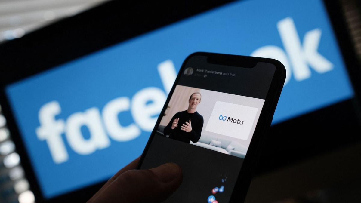 Mark Zuckerberg,  a lapantalla d’un mòbil durant la presentació del logo de Meta. |  CHRIS DELMAS / AFP
