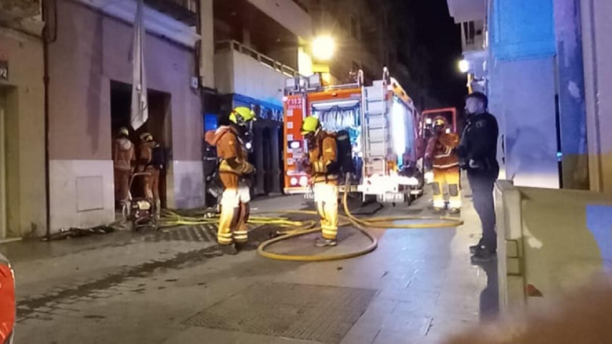 Bomberos trabajando en la extinción del incendio en la calle Gomis de Ontinyent.