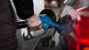 Un hombre reposta en una gasolinera.