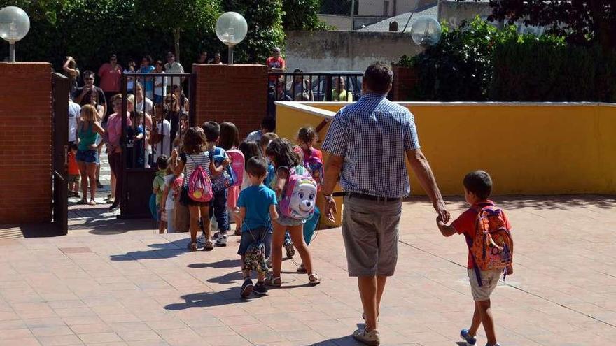 Un grupo de niños sale de clase en un centro de Benavente.