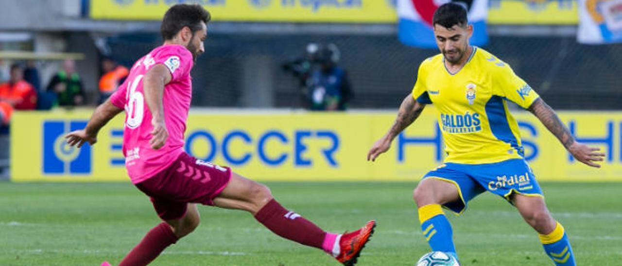 El atacante de la UD Tana controla el esférico, ayer, ante la oposición de Aitor Sanz, durante una acción del primer tiempo en el Gran Canaria.