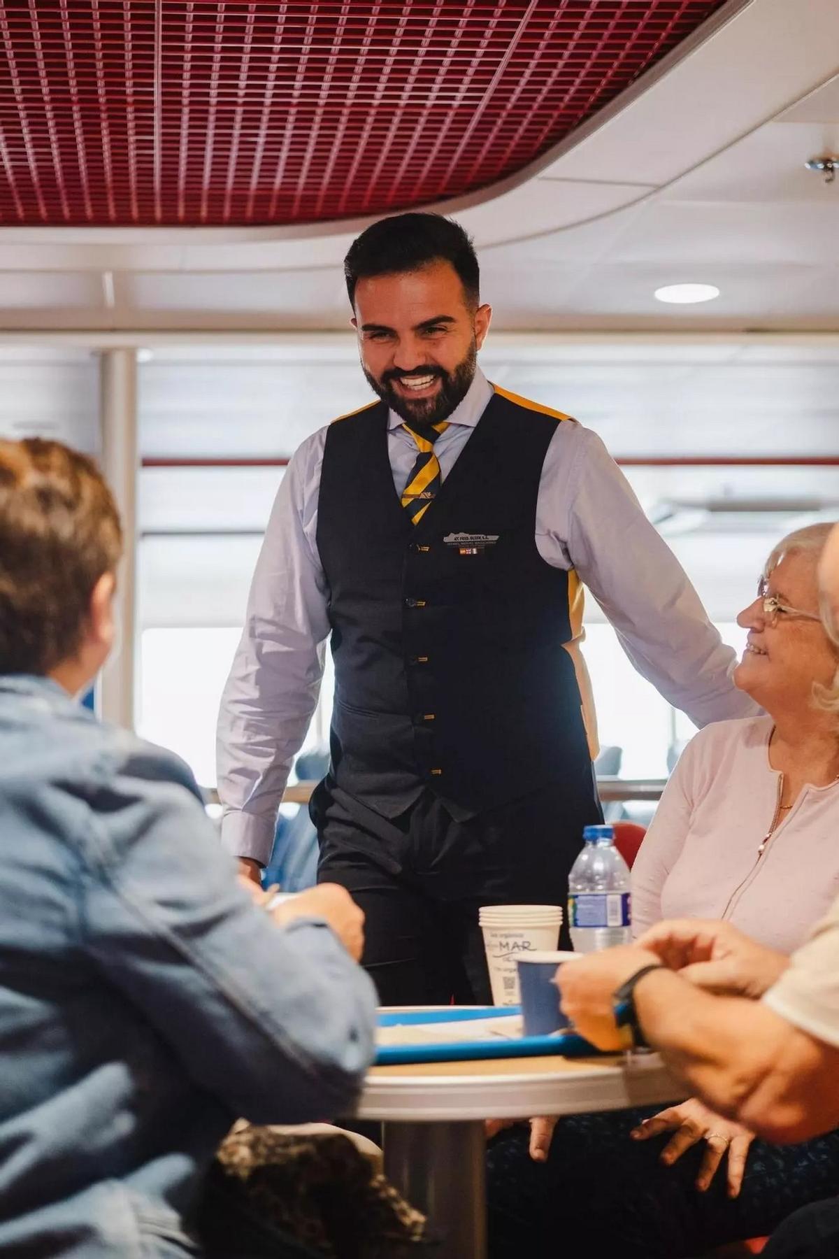 Auxiliar de cabina atendiendo a pasajeros a bordo.