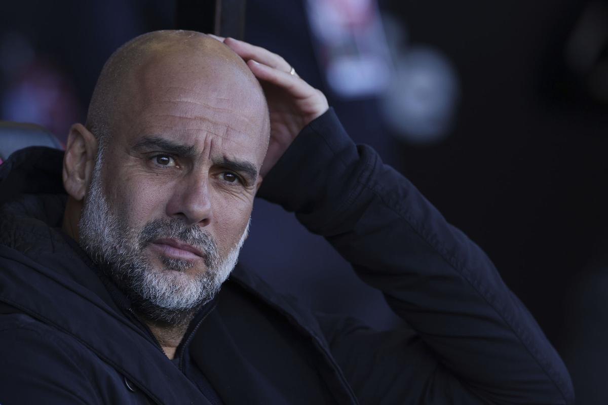 Manchester City's head coach Pep Guardiola looks out from the bench before the English FA Cup quarterfinal soccer match between Bournemouth and Manchester City at the Vitality stadium in Bournemouth, England, Sunday, March 30, 2025. (AP Photo/Ian Walton)
