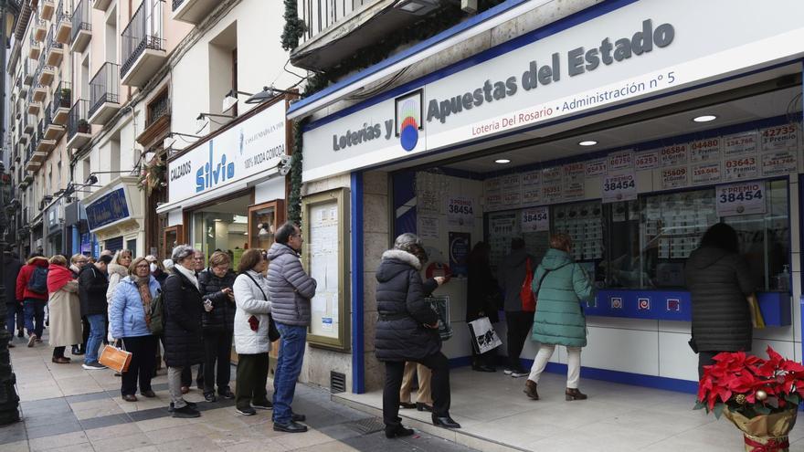 Una fila bastante considerable de clientes se agolpa a las puertas de la Administración de Lotería número 5 de Zaragoza, en la calle Don Jaime. | ANDREEA VORNICU