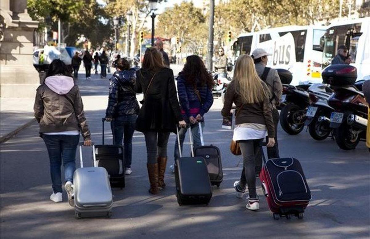 Turistes amb maletes pels carrers de Barcelona.