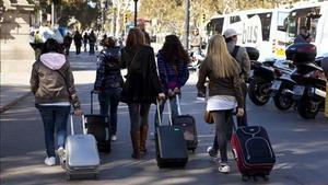 Turistes amb maletes pels carrers de Barcelona.