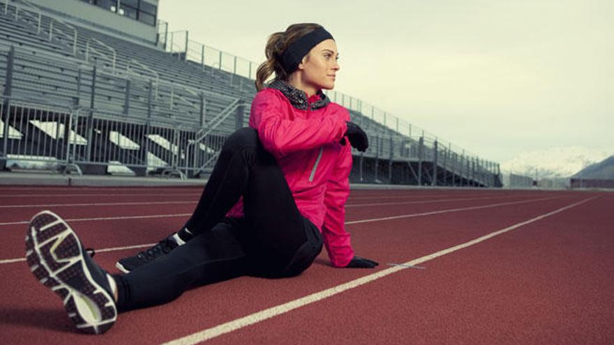 Una joven practica deporte en una pista de atletismo.