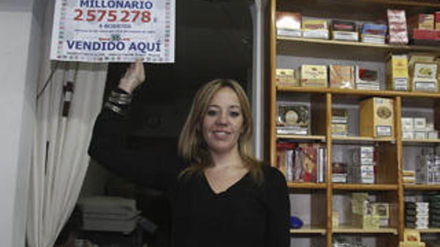 Cristina Fernández y el empleado Salvador Clemades posan señalando el premio millonario