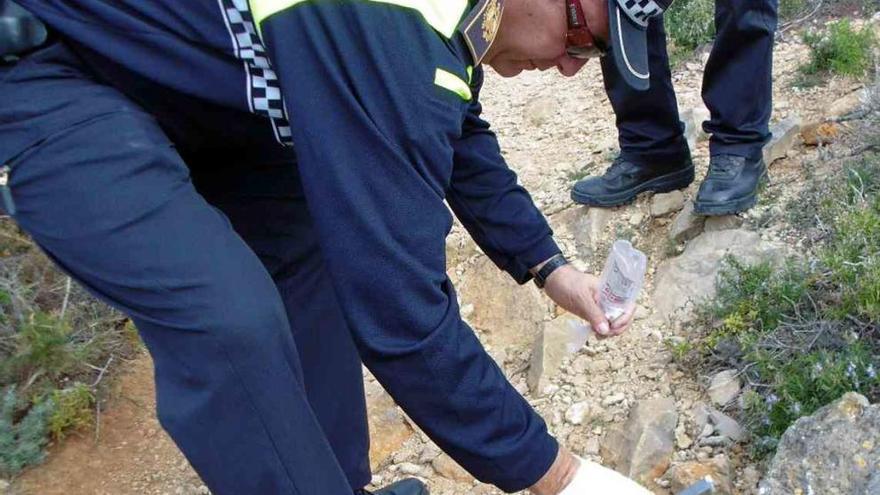 Un policía recoge una muestra de polvo blanco.