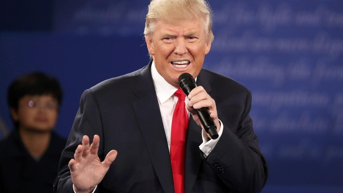 Republican U.S. presidential nominee Trump speaks as Democratic U.S. presidential nominee Clinton listens during their presidential town hall debate in St. Louis