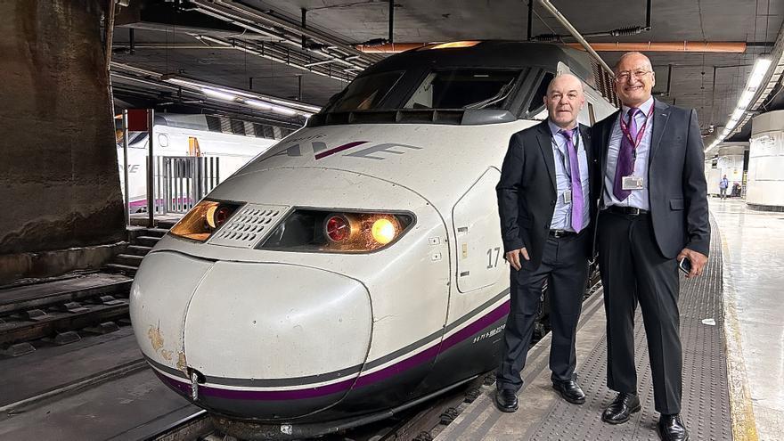 Alberto y Jordi, los dos primeros maquinistas de la línea Barcelona-Lyon, en la estación de Sants, este jueves. A su lado, el tren AVE que será el primero en cruzar el túnel del Pertús con pasajeros.