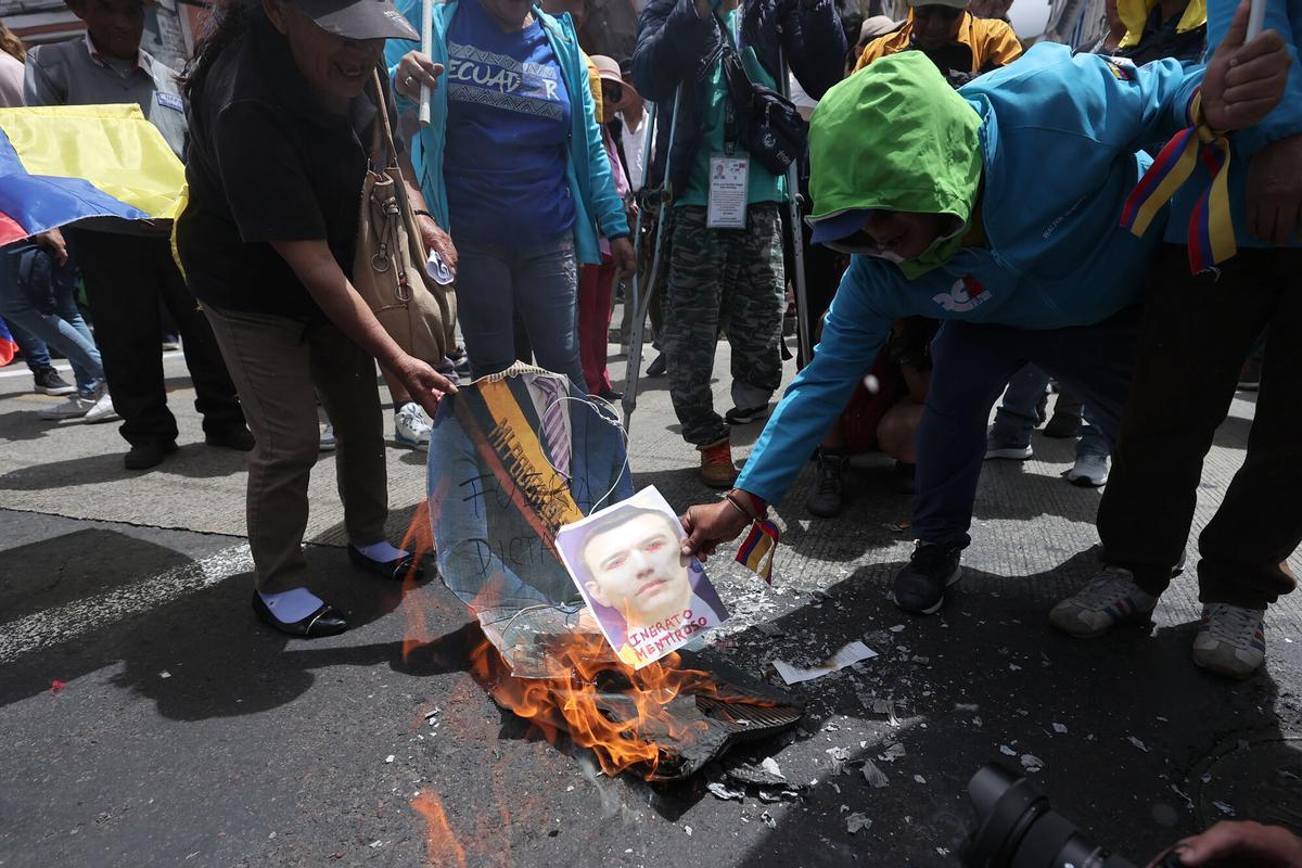 Personas queman una imagen del presidente de Ecuador durante una manifestación en Quito.