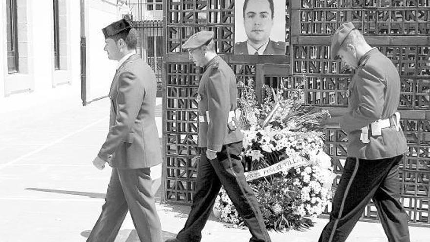 Dos ertzainas y un guardia civil, al término de la ofrenda floral en el Parlamento vasco por el agente asesinado por ETA.