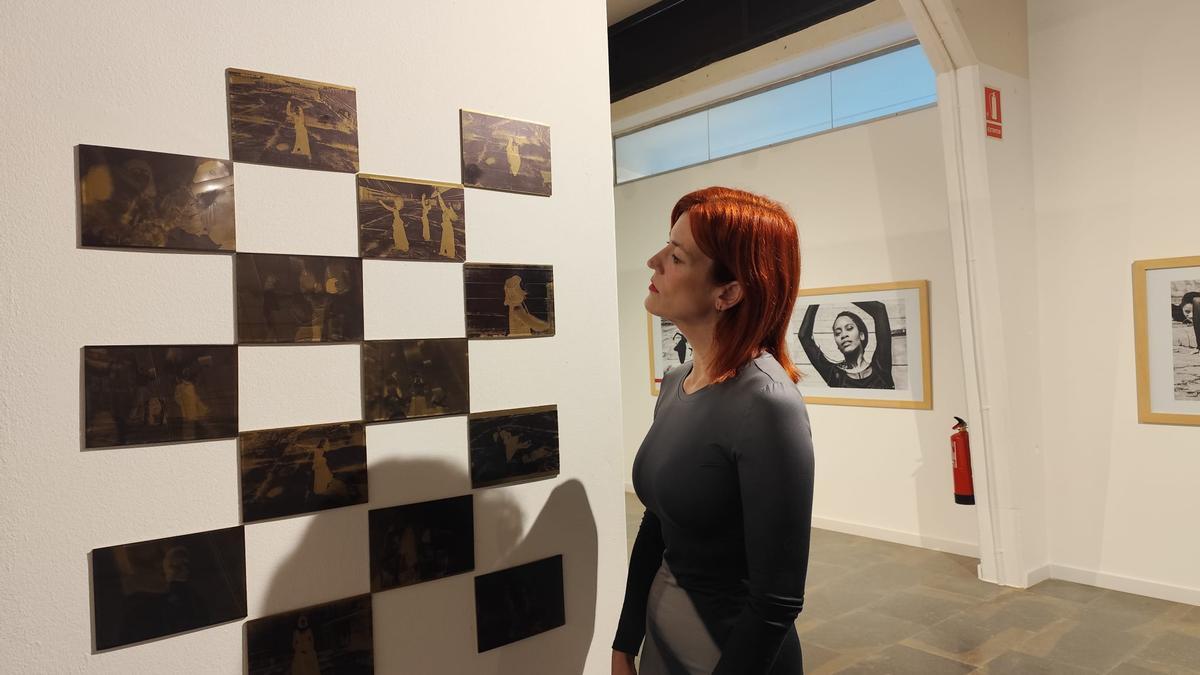 Emma Alcalá contemplant els negatius que fan de vas comunicant entre ambdues exposicions.