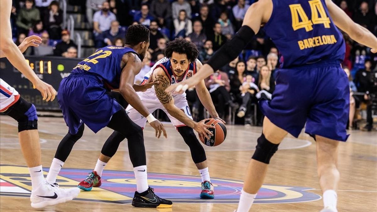 Shane Larkin, base del Efes, controla el balón en presencia de Higgins