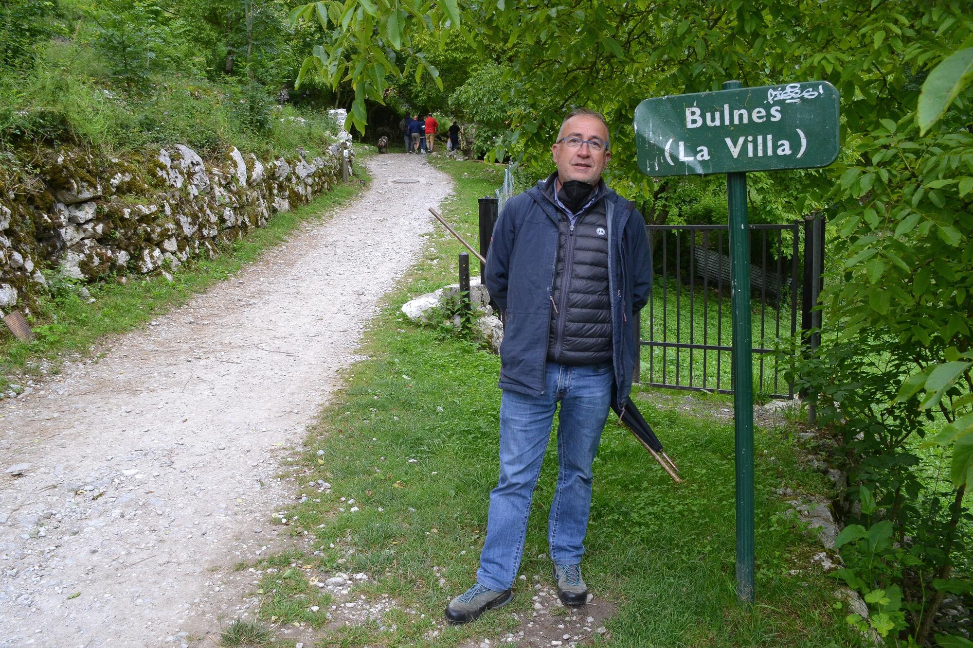 José Antonio Garcia, el regidor de pastos de la Montaña de Covadonga, junto a la señalización del pueblo de Bulnes.