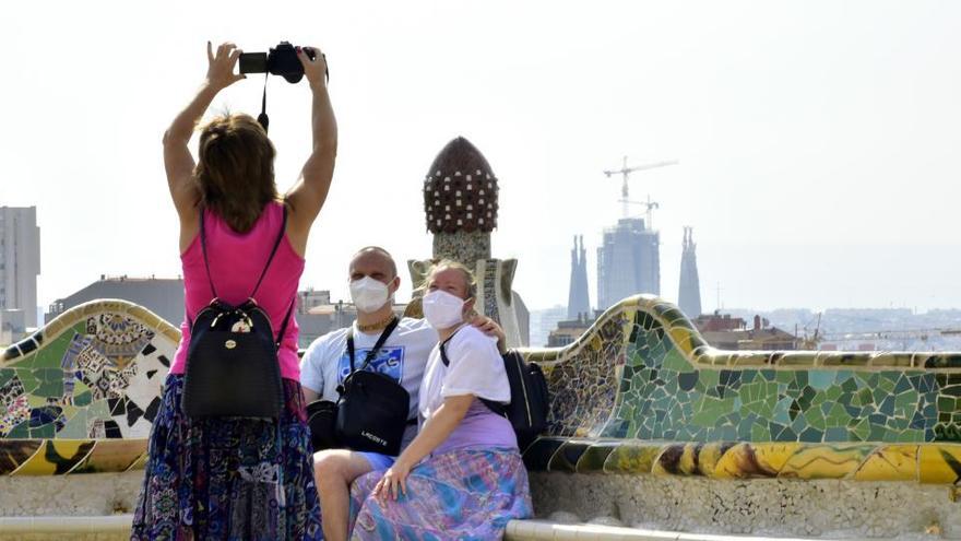 Una mujer realiza una fotografía a dos turistas.