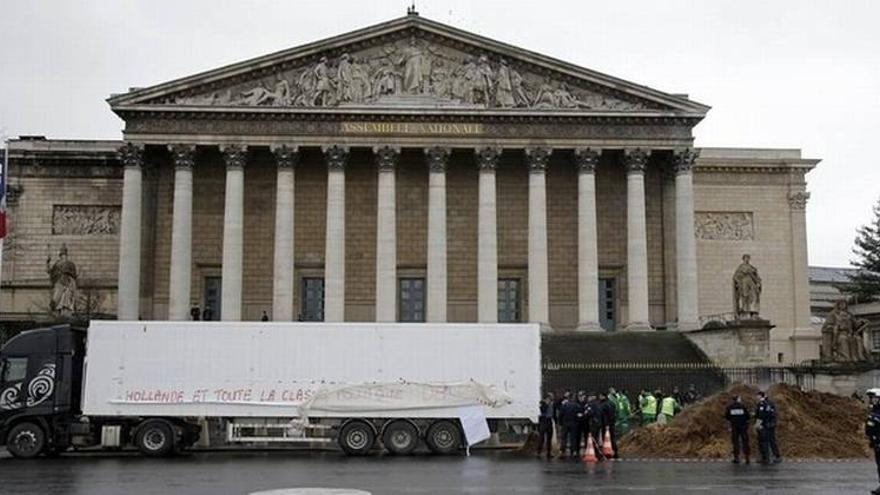 Un camionero vierte un montón de estiércol ante la Asamblea Nacional francesa