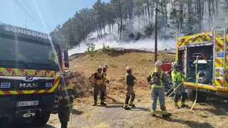 Tres helicópteros luchan contra un incendio forestal cerca de las casas en Vincios