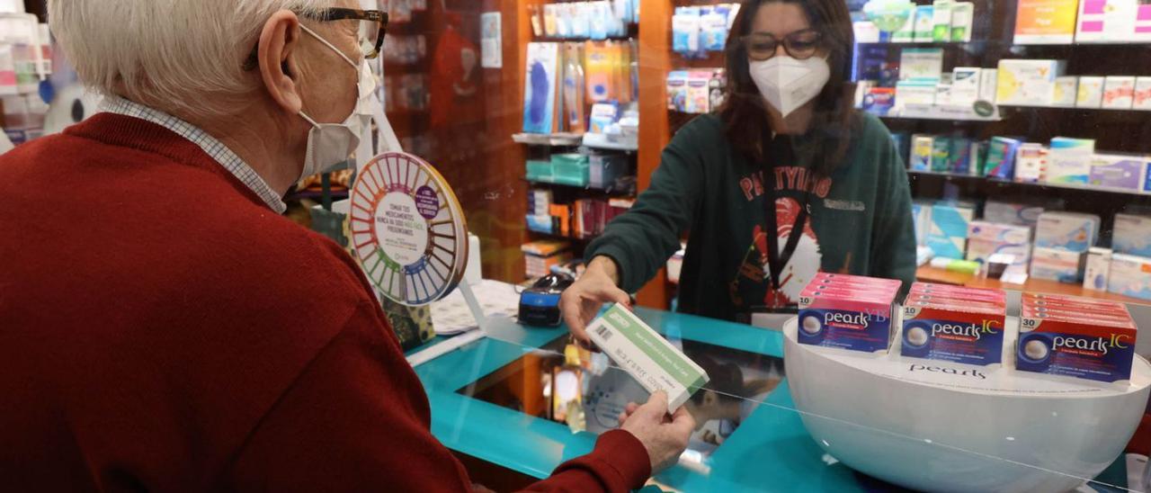 Un hombre adquiere un test de antígenos en una farmacia de Vigo.