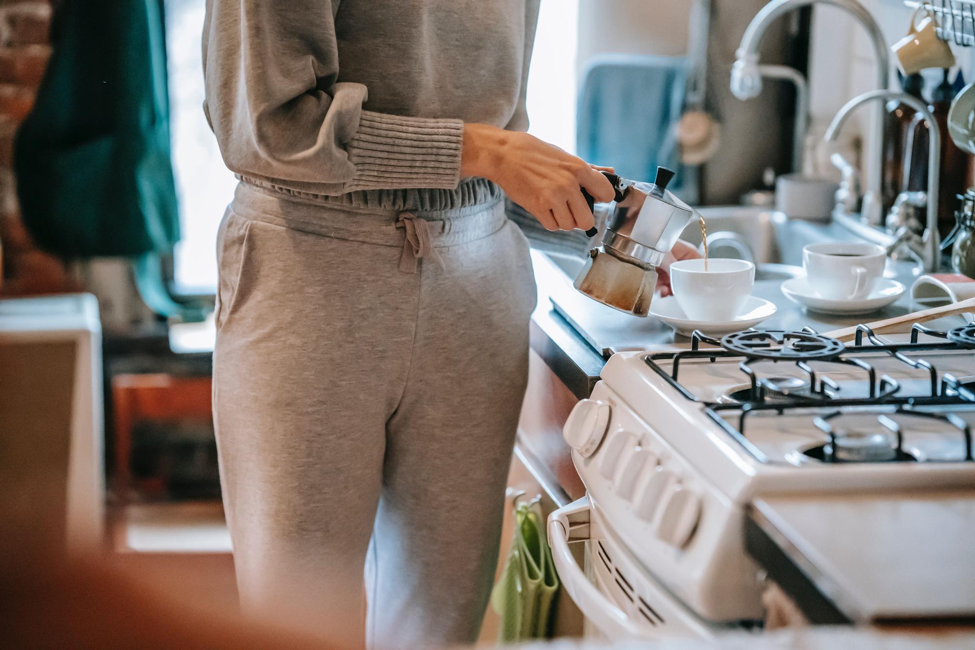 Una mujer haciendo café en casa