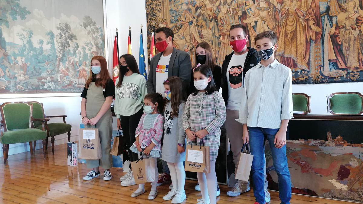 Autoridades locales posan con los niños ganadores del concurso literario y de dibujo sobre la vendimia